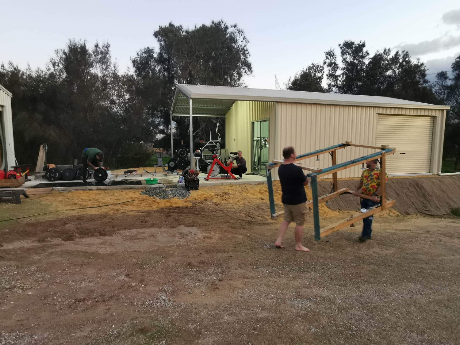 Ryan and Paul carrying the original wooden rack during the Castle FY shed build.